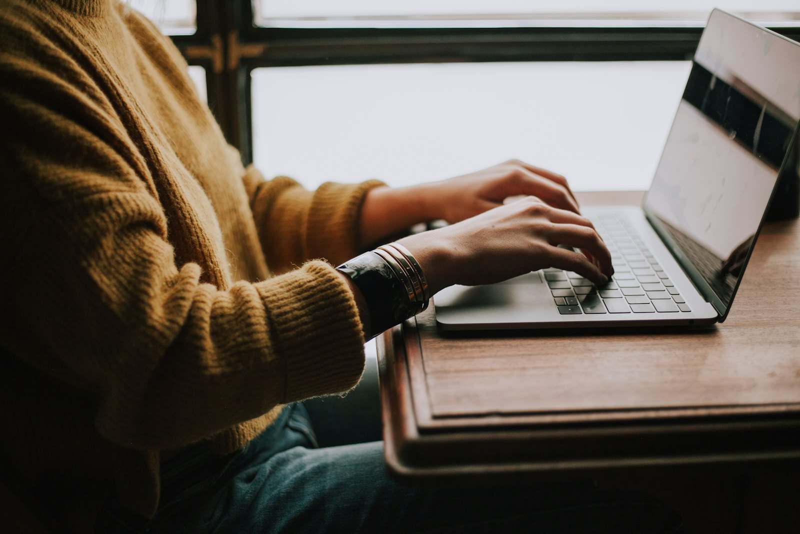 Des mains sur le clavier d’un ordinateur portable
